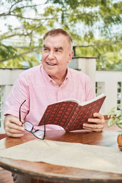 Hombre mayor positivo con libro