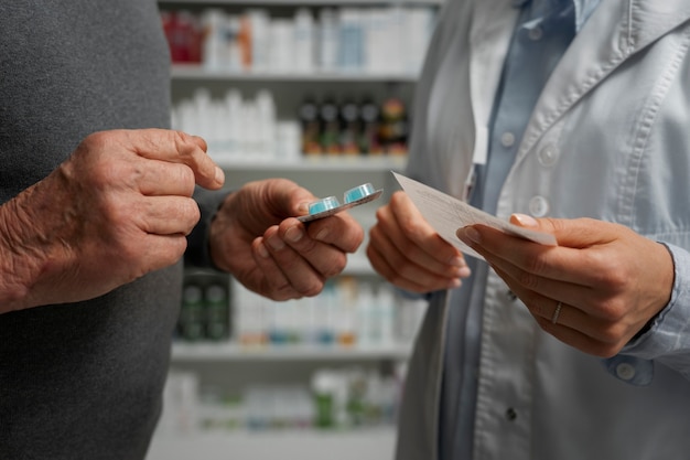 Foto gratuita hombre mayor que consulta a una farmacéutica sobre medicamentos