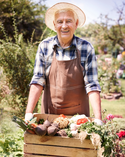 Hombre mayor que trabaja en el campo con flores