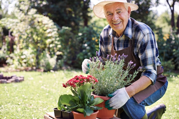 Hombre mayor que trabaja en el campo con flores