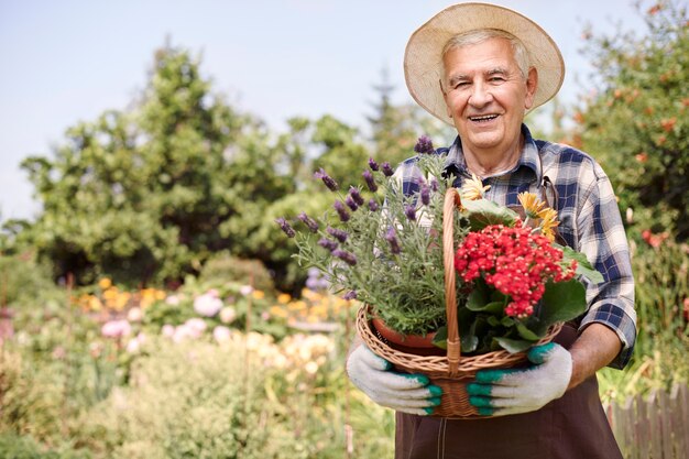 Hombre mayor que trabaja en el campo con flores