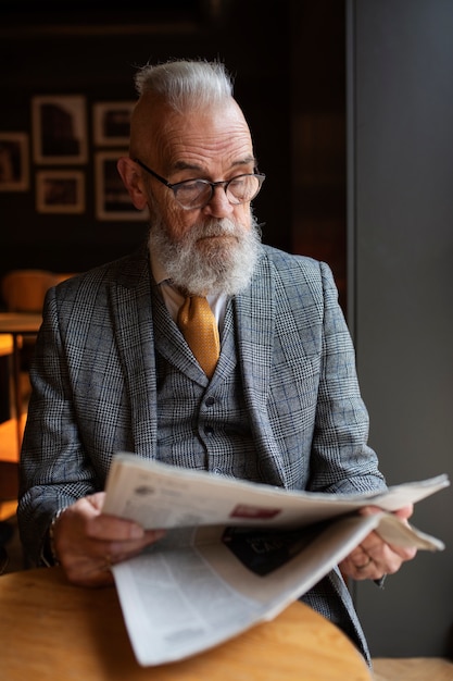 Foto gratuita hombre mayor de tiro medio leyendo en el café