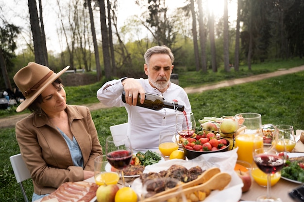 Hombre mayor de tiro medio sirviendo vino