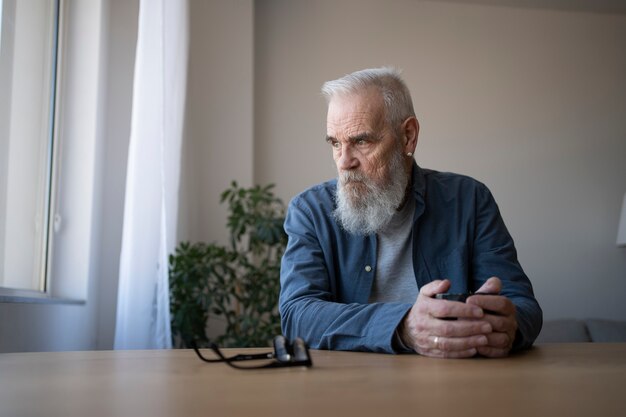 Hombre mayor triste en casa