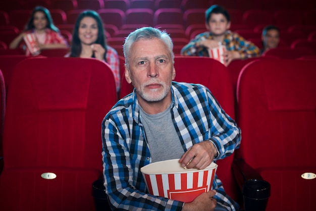 Hombre mayor viendo película en cine