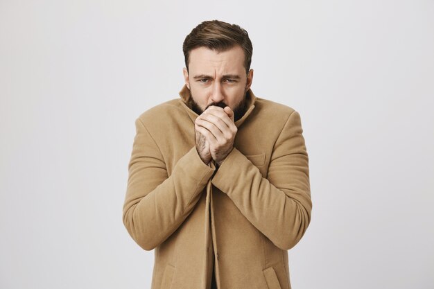 Hombre de mediana edad con barba que se siente frío en la calle