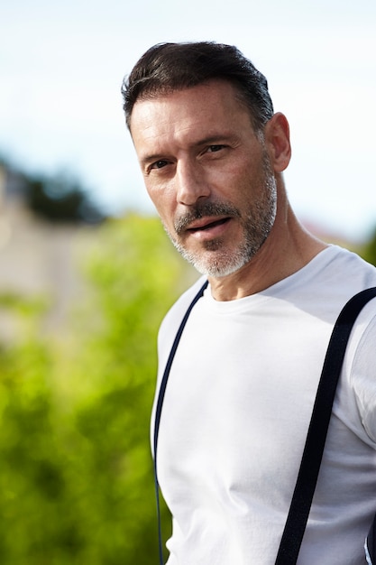 Hombre de mediana edad con camisa blanca con tirantes