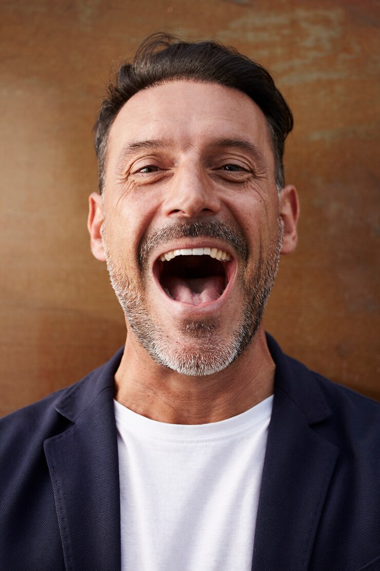Hombre de mediana edad con una chaqueta riendo feliz