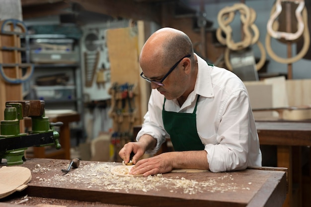 Hombre de mediana edad haciendo instrumentos en su taller solo