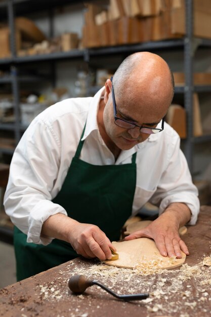 Hombre de mediana edad haciendo instrumentos en su taller solo