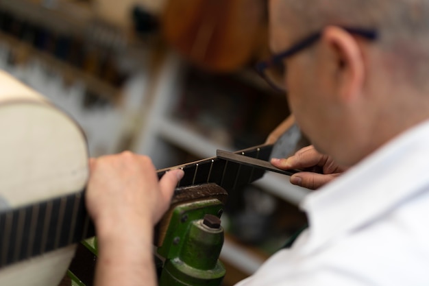 Hombre de mediana edad haciendo instrumentos en su taller solo