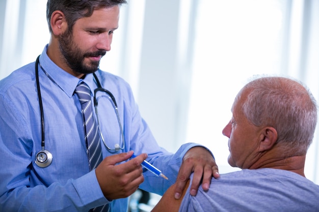 Hombre médico que den una inyección a un paciente