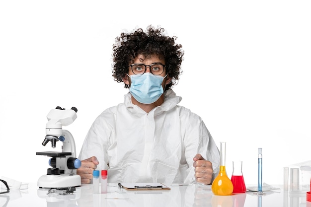 Foto gratuita hombre médico en traje de protección máscara estéril sentado en blanco