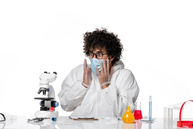 Hombre médico en traje de protección y máscara trabajando con cara de sorpresa en blanco