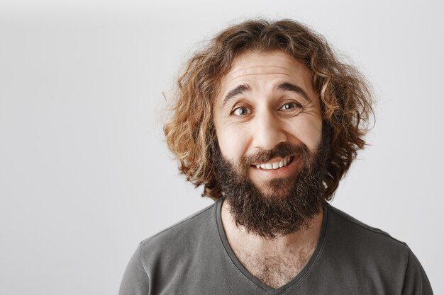 Hombre del Medio Oriente sonriente vacilante que parece inseguro