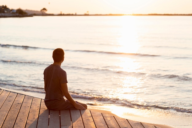 Hombre meditando en la playa