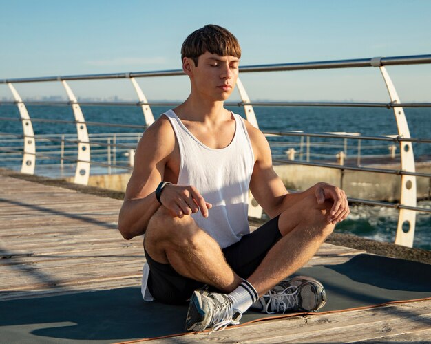 Hombre meditando en la playa