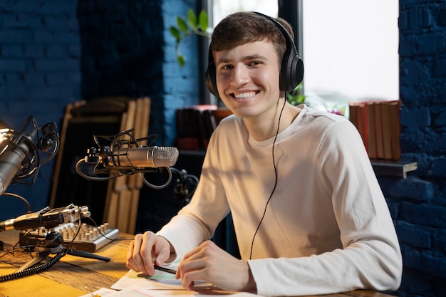 Hombre con micrófono y auriculares ejecutando un podcast en el estudio