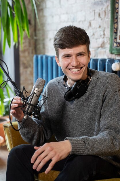 Hombre con micrófono y auriculares ejecutando un podcast en el estudio