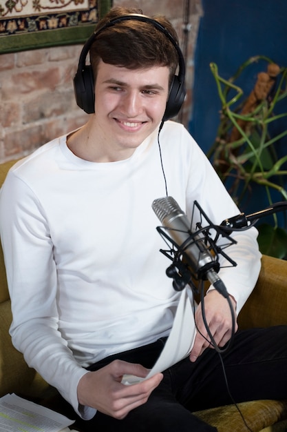 Hombre con micrófono y auriculares ejecutando un podcast en el estudio