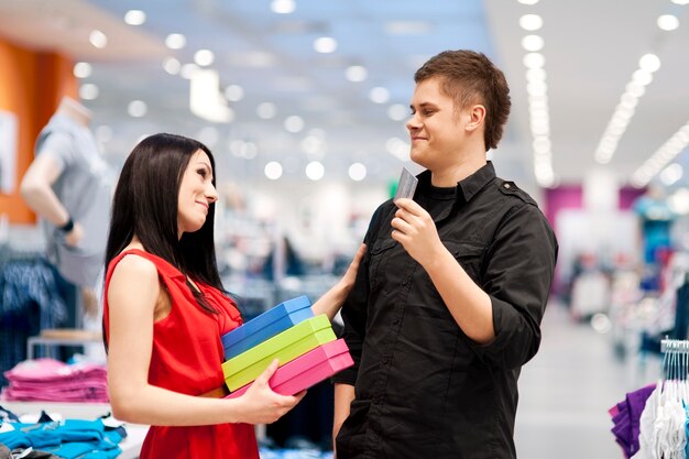 Hombre mimando a su novia comprándole ropa nueva