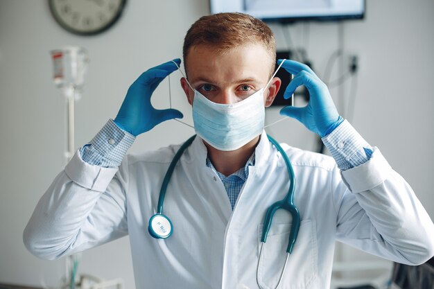 El hombre mira a la cámara. Estudiante practica la medicina. Enfermera en bata de baño y estetoscopio.