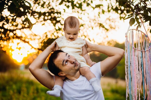 El hombre mira a la niña mientras ella se sienta en su cuello