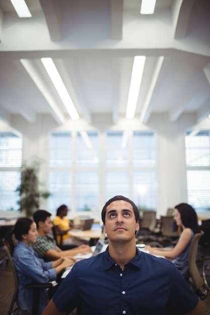 Hombre mirando hacia arriba mientras trabajan en segundo plano