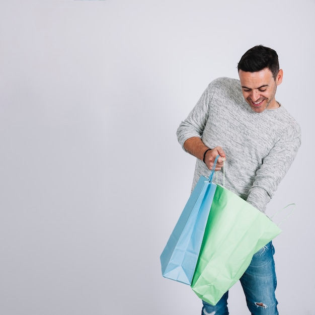 Foto gratuita hombre mirando en bolsa de compra