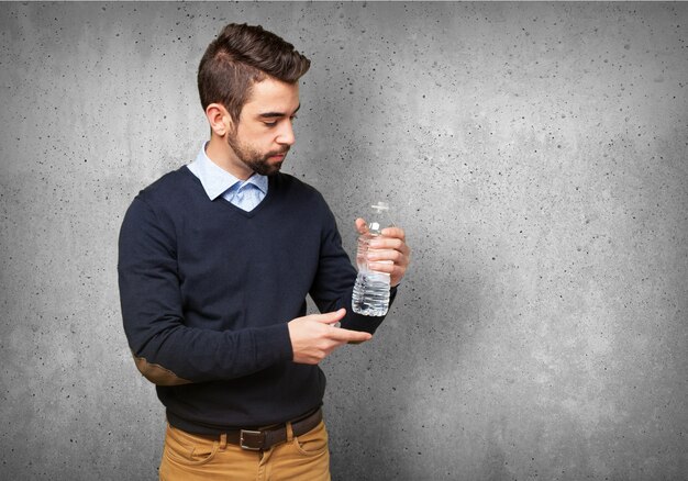 Hombre mirando una botella de agua