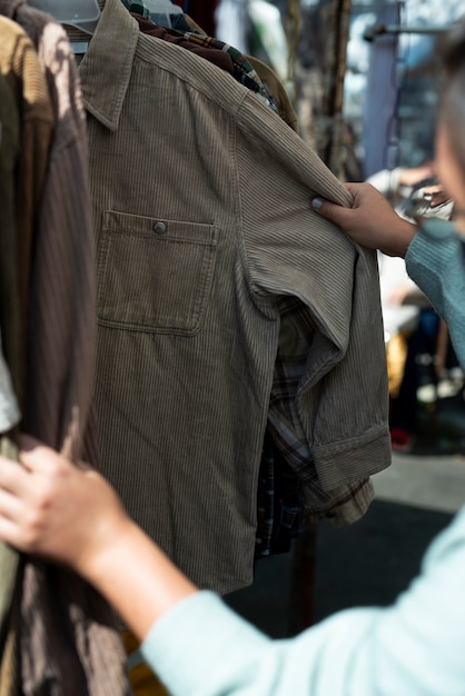 Foto gratuita hombre mirando camisetas en el mercado de segunda mano