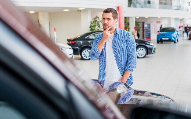 Hombre mirando un coche nuevo