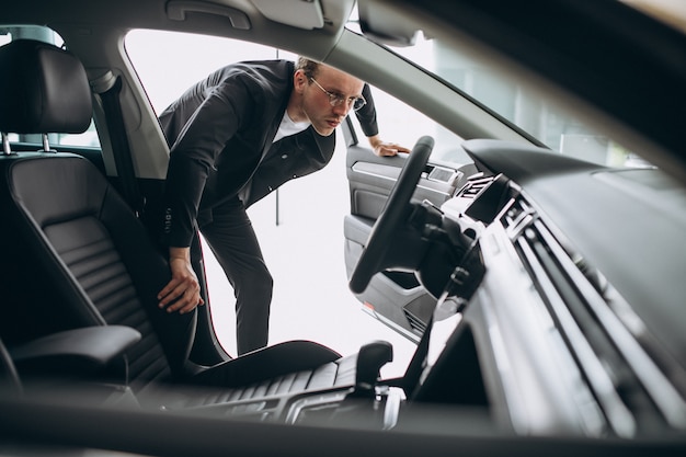 Hombre mirando un coche en una sala de exposición de coches