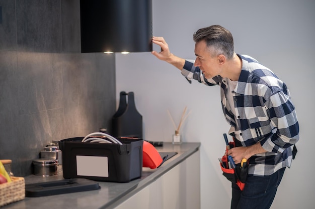 Foto gratuita hombre mirando la iluminación de la campana de la cocina