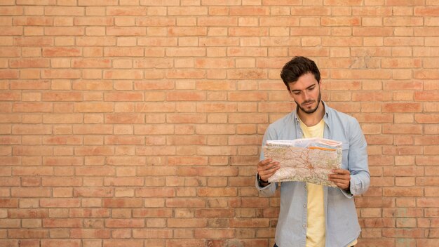 Hombre mirando un mapa con espacio de copia