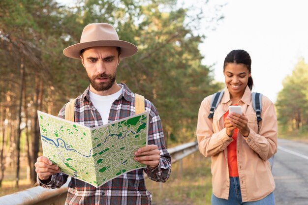 Hombre mirando un mapa mientras viaja con su novia