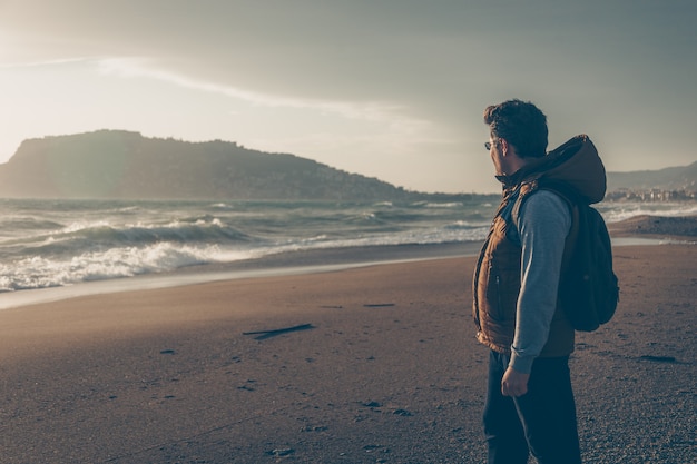 Hombre mirando la playa de Sein durante el día y mirando pensativo