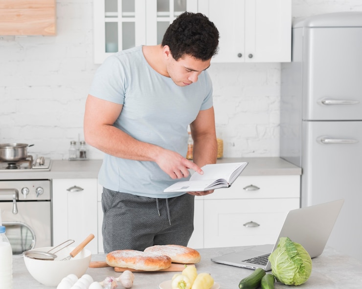 Foto gratuito hombre mirando desde recetas en línea