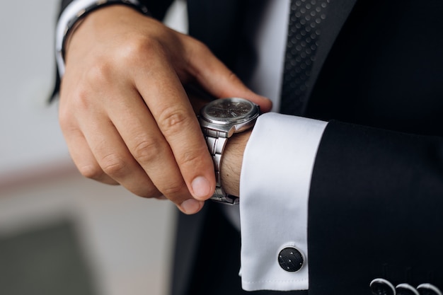 Foto gratuita el hombre está mirando el reloj en su muñeca.