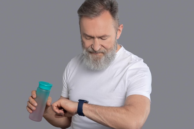 Un hombre mirando el reloj en sus manos.