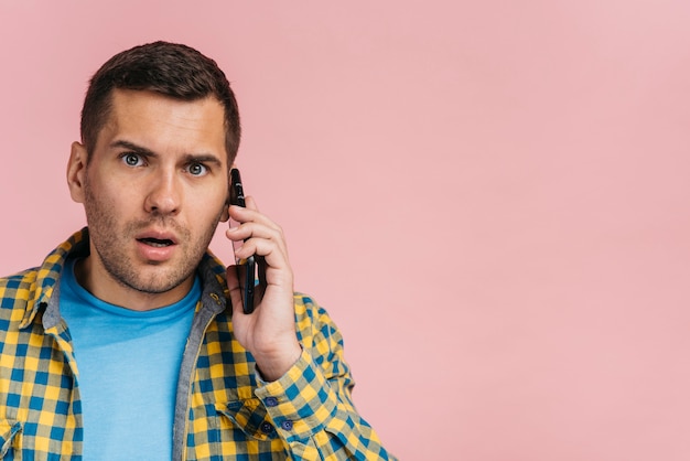 Hombre mirando sorprendido mientras habla por teléfono