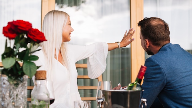 Hombre mirando a su novia con anillo de diamantes en el restaurante