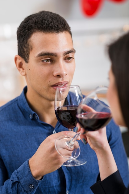Hombre mirando a su novia mientras sostiene una copa de vino