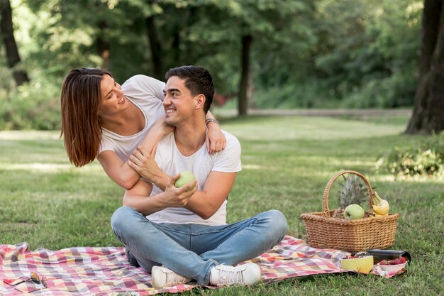 Hombre mirando a su novia mientras sostiene una manzana