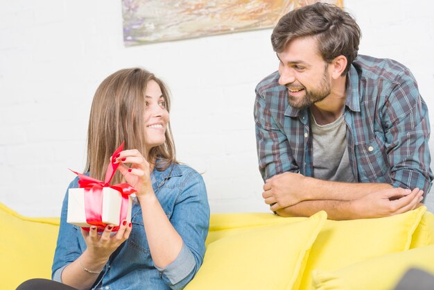 Hombre mirando a su novia con regalo de cumpleaños