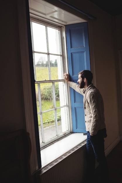 Foto gratuita hombre mirando por la ventana