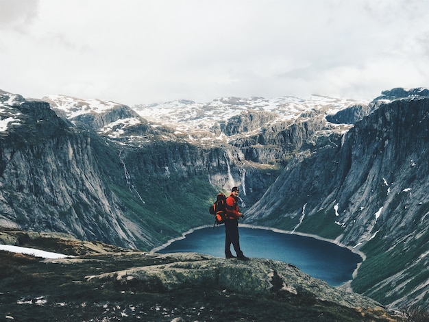 El hombre con una mochila admira el paisaje de montaña magnífico