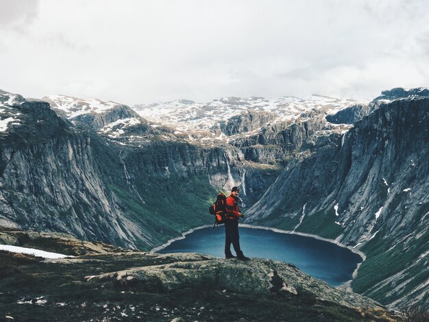 El hombre con una mochila admira el paisaje de montaña magnífico