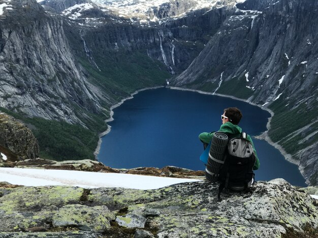 El hombre con una mochila admira el paisaje de montaña magnífico