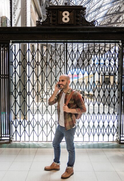 Hombre con mochila hablando por teléfono